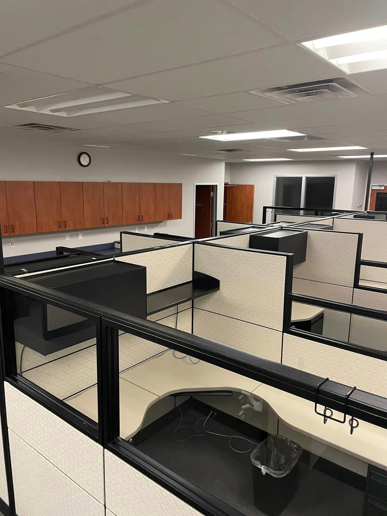 Equipo de limpieza aspirando y limpiando escritorios en una oficina de Omaha, NE
